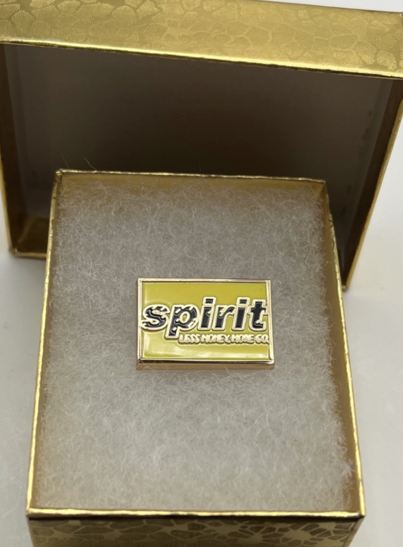 Spirit Airlines yellow wordmark lapel pin — modern cloisonné reproduction.