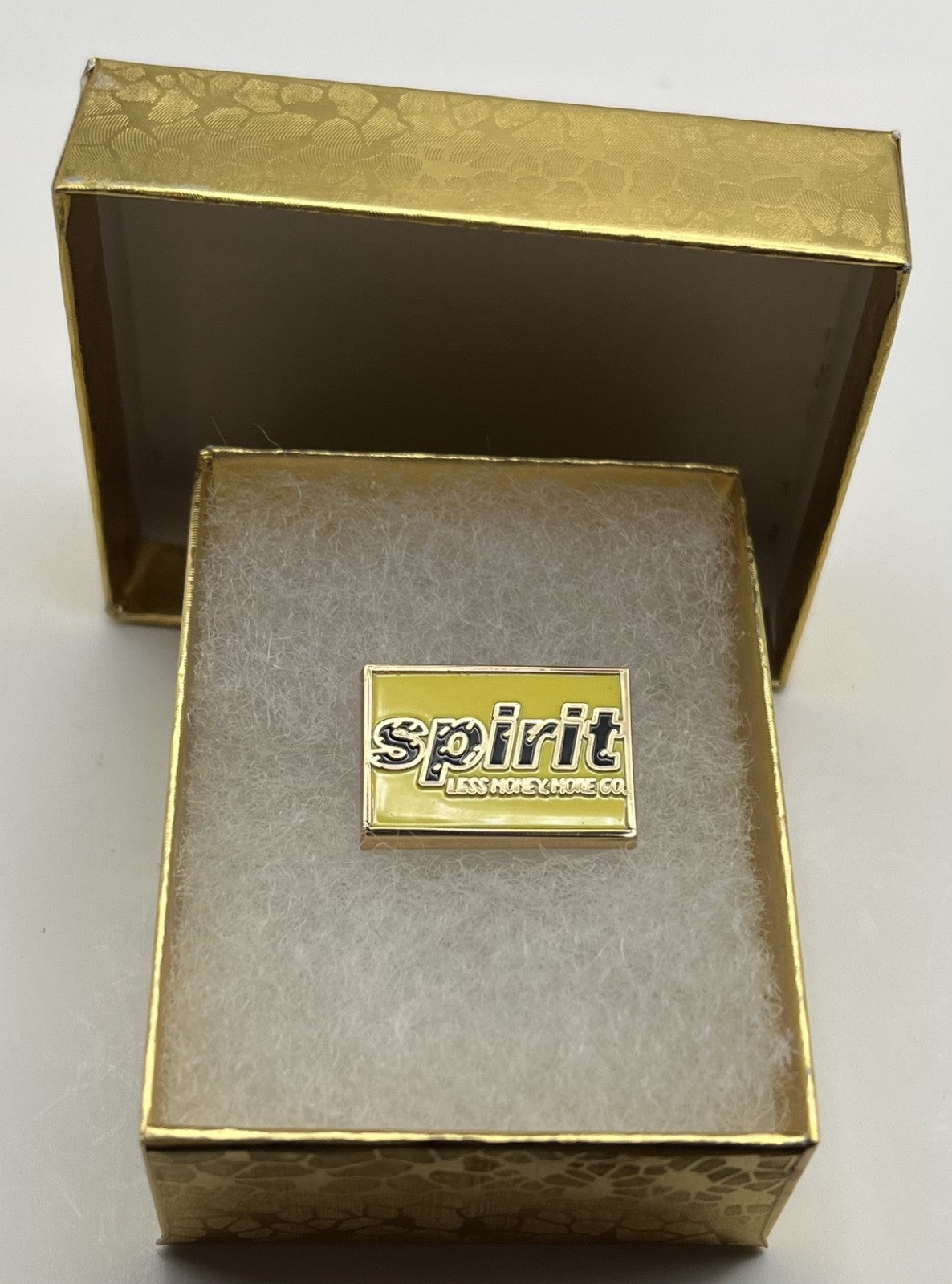 Spirit Airlines yellow wordmark lapel pin — modern cloisonné reproduction.
